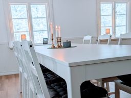 Helles Schlafzimmer mit einem weißen Bett und Nachttisch, dekoriert mit Tapete.